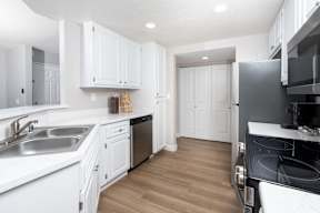 A kitchen with white cabinets and a black stove top oven.