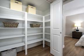 A white closet with shelves and baskets.