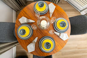 A table set for four with yellow and grey plates.
