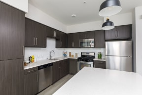 Apartments for Rent in Los Angeles - Wakaba LA - Modern Kitchen with Wood-Style Cabinets, White Countertops & Stainless Steel Appliances