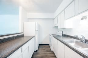 a kitchen with white cabinets and granite counter tops and a sink