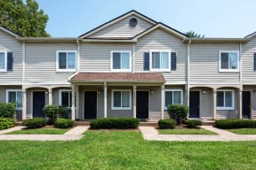 a large gray house with a yard in front of it
