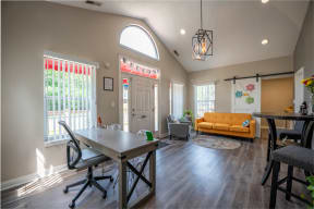 the view of the living room from the dining room with a table and chairs