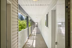a long porch with white siding and a white railing at Mill Pond Apartments, Auburn Washington