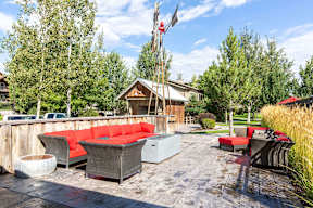 Outdoor patio with red cushioned seating and fireplace at Mullan Reserve Apartments, Missoula, 59808