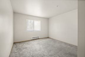 a bedroom with white walls and carpet at Mill Pond Apartments, Auburn Washington