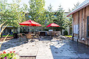 Outdoor patio area with grilling stations and seating at Mullan Reserve Apartments, Montana