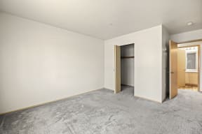 a bedroom with white walls and a carpeted floor at Mill Pond Apartments, Auburn