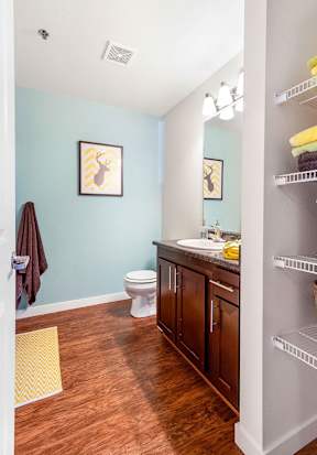 Bathroom with wood flooring and dark vanity at Mullan Reserve Apartments, Missoula, Montana