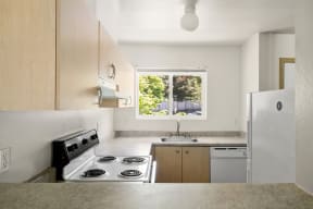 a kitchen with a stove top oven next to a sink at Mill Pond Apartments, Washington