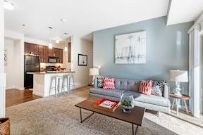 Living room with gray sofa and blue accent wall at Mullan Reserve Apartments, Missoula, MT