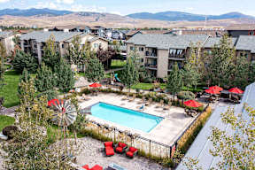 Aerial view of pool area with mountain backdrop at Mullan Reserve Apartments, Montana