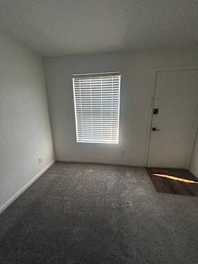 A room with a window and a concrete wall.