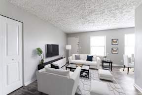 a living room with white furniture and a tv
