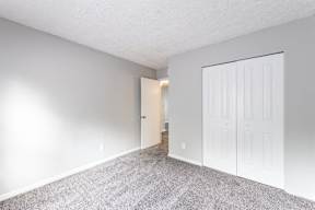 a bedroom with a closet and a door to a hallway