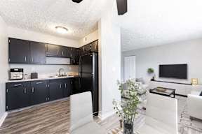a kitchen and living room with a black refrigerator