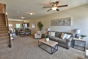 a living room with a couch and a ceiling fan