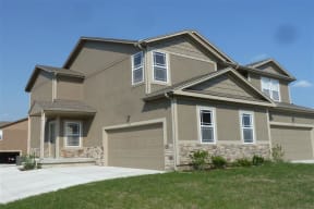 a beige house with a garage and a driveway
