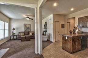 a living room and a kitchen with a ceiling fan