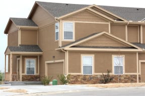 a brown house with a street in front of it