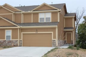 a brown house with a garage door in front of it