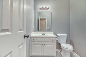 a bathroom with a toilet sink and a mirror