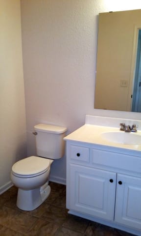 a bathroom with a toilet sink and a mirror
