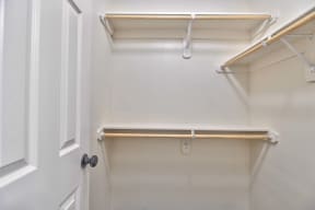 a walk in closet with a shelf and a door