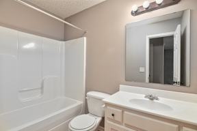 A white bathroom with a toilet, sink, and bathtub.