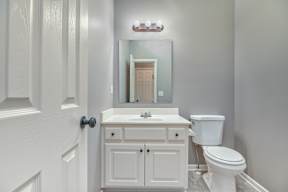 A white bathroom with a toilet, sink, and medicine cabinet.