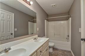 A bathroom with a white sink and a white toilet.
