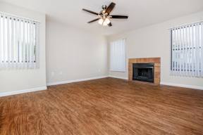 A room with a fireplace and a ceiling fan.