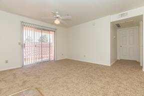 A room with a ceiling fan and carpeted floor.
