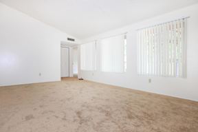 A large empty room with carpeted floor and white walls.