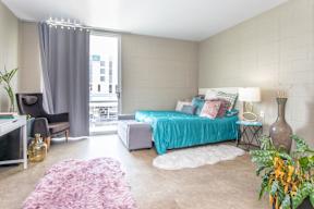 A bedroom with a large bed and a chair.