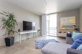 A living room with a grey couch and a television on a stand.