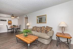A living room with a couch, a coffee table, and a dining table.