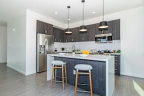 A modern kitchen with a large island and bar stools.