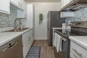 A kitchen with a black refrigerator and a white oven.