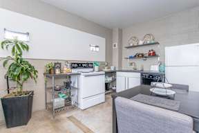 A kitchen with a grey couch and a potted plant.