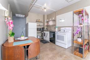 A kitchen with a table and chairs and a refrigerator.