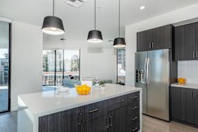 A modern kitchen with a white countertop and black cabinets.