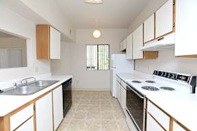 A kitchen with white appliances and wooden cabinets.
