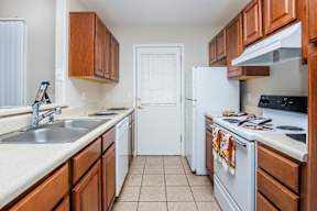A kitchen with white appliances and wooden cabinets.