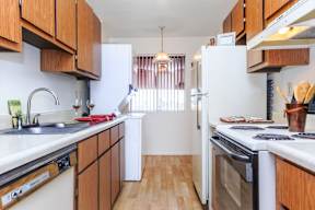 A kitchen with white appliances and wooden cabinets.