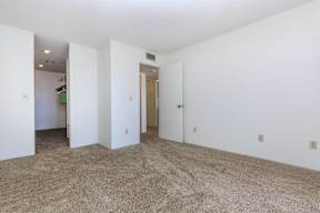 A room with white walls and carpeted floor.