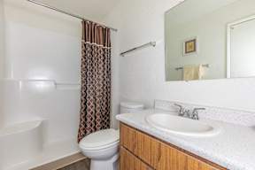 A white toilet sits next to a white sink in a bathroom.