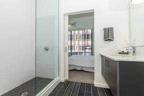 A bathroom with a walk in shower and a sink.