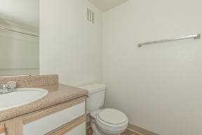 A white toilet sits next to a sink in a bathroom.