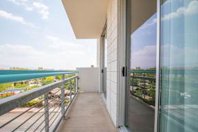 A balcony with glass doors leading to a patio.